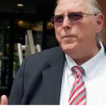 A man in suit and tie talking to someone.