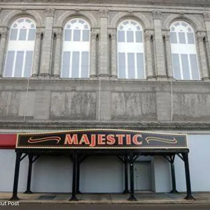 A majestic sign is shown in front of an old building.