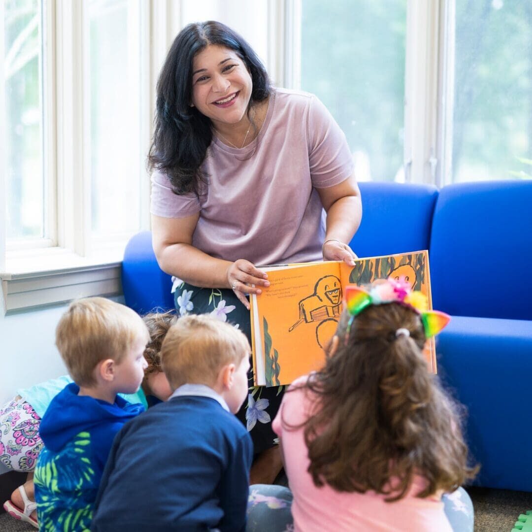 A woman reading to children in a room.